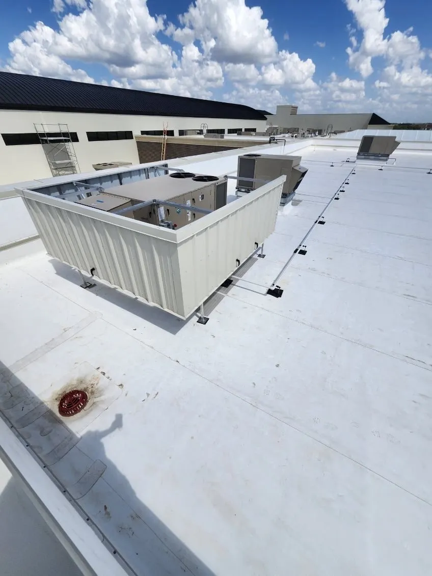 Beige corrugated RTU screen surrounding packaged rooftop HVAC equipment