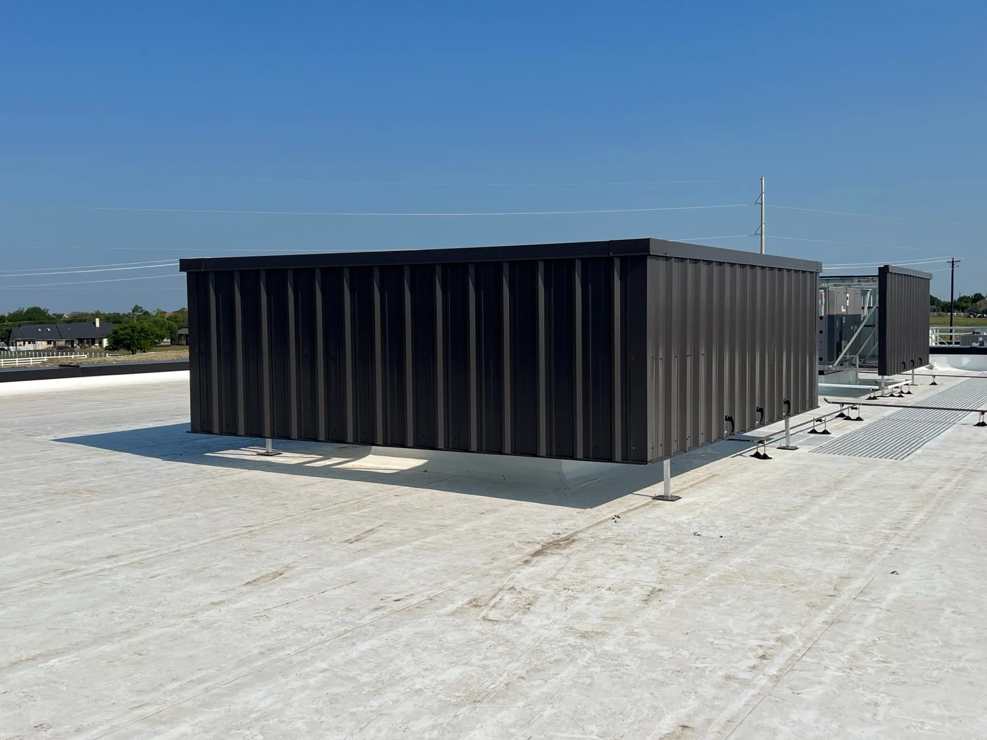 Charcoal steel RTU screen enclosure on a light commercial rooftop