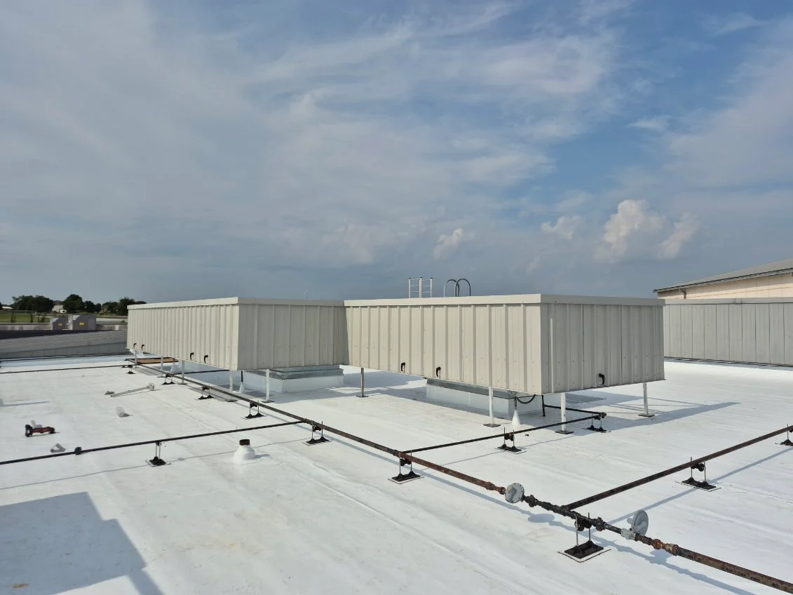 Pair of beige steel RTU screens on a white commercial rooftop